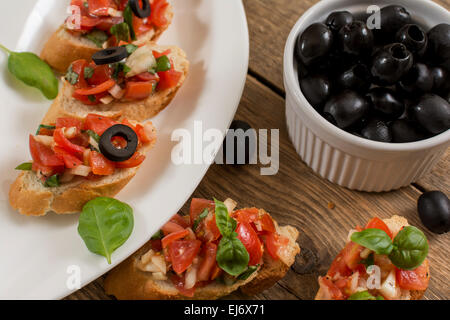 Treditional italienne bruschetta à la tomate et basilic olives noires Banque D'Images