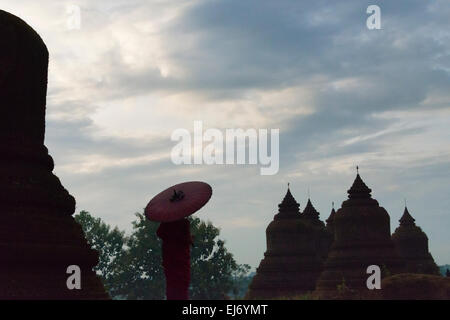 Monk holding parapluie rouge avec Andaw thein-Temple, Mrauk-U, l'État de Rakhine, au Myanmar Banque D'Images