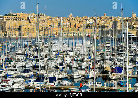 La voile des bateaux amarrés dans le grand port de plaisance de Vittoriosa contre le pittoresque arrière-plan de la Valette, Malte Banque D'Images
