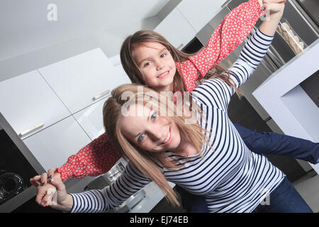 Mère et sa fille debout dans la cuisine. Portrait de l'intérieur. Banque D'Images