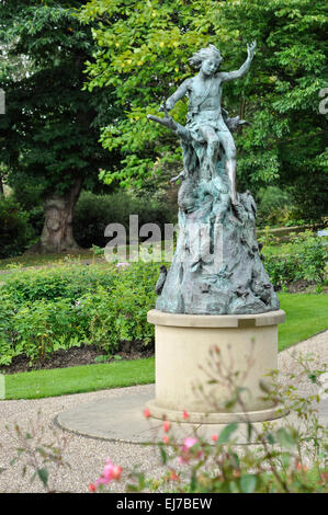 Statue de Pan, esprit de la forêt à Sheffield Botanical Gardens. Statue en bronze dans le jardin de roses. Banque D'Images