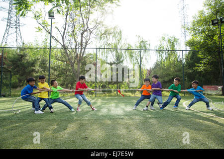 Les garçons sont à la corde sur l'herbe Banque D'Images
