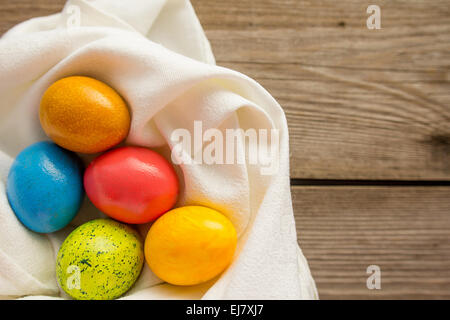 5 Les oeufs de Pâques colorés sur la serviette blanche Banque D'Images