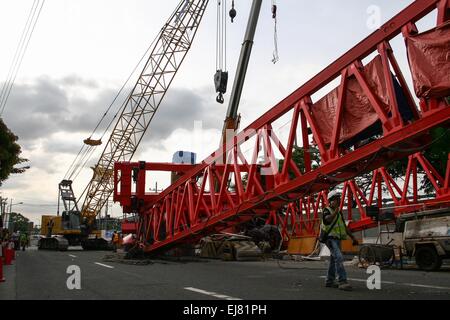 Manila, Philippines. Mar 23, 2015. Les travailleurs de la construction mise en place d'une grue pour enlever la poutre effondrée launcher le long de l'Avenue d'Andrew à Pasay. À environ 3 dans l'après-midi aujourd'hui, sur l'Avenue, près de Andrew Tramo à Pasay City, une poutre de lancement, à partir de la construction de l'autoroute de la NAIA, c'est effondré, causant des dommages à des voitures qui passent. Aucun rapport de blessés, mais l'incident endommagé au moins 5 voitures et provoqué un fort trafic le long de l'Avenue d'Andrew. Crédit : J Gerard Seguia/Pacific Press/Alamy Live News Banque D'Images