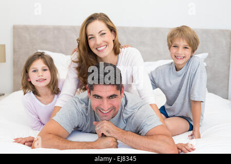 Heureux les enfants et les parents au lit Banque D'Images