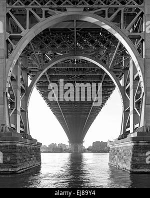 Vue en noir et blanc de sous le pont de Williamsburg à New York sur un jour brumeux Banque D'Images