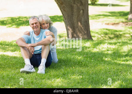 Young couple sitting on grass at park Banque D'Images