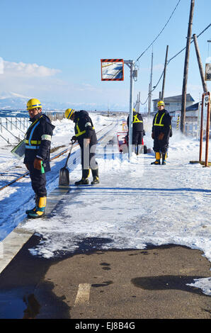 Le personnel de la station de train de pelleter la neige Banque D'Images