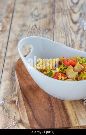 Bol à riz parfumé au curry de poulet et de légumes sur une table en bois rustique Banque D'Images