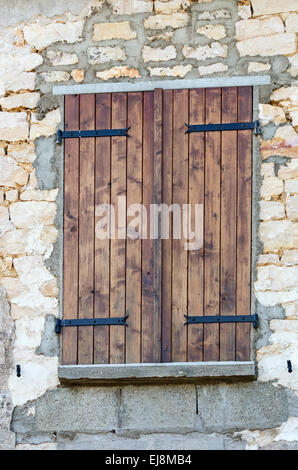 Volets bois protéger la fenêtre d'une vieille maison en pierre dans le village de Gigny-safe-Saône, Bourgogne, France. Banque D'Images