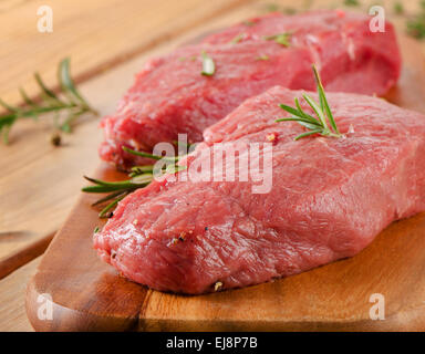 Steak cru sur table en bois. Selective focus Banque D'Images