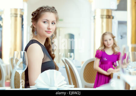 De jolies jeunes sœurs posing at restaurant Banque D'Images