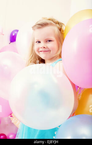 Funny little girl posing with balloons Banque D'Images