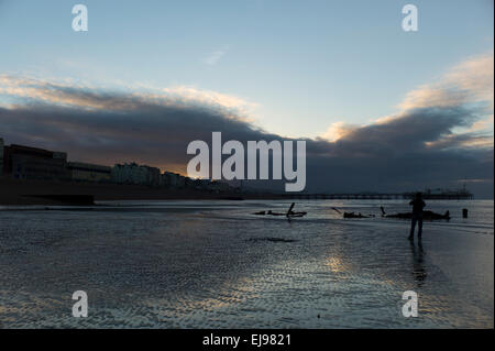 L'homme en silhouette, le lever du soleil, la plage de Brighton, marée basse, marée basse,nuage spectaculaire Banque D'Images