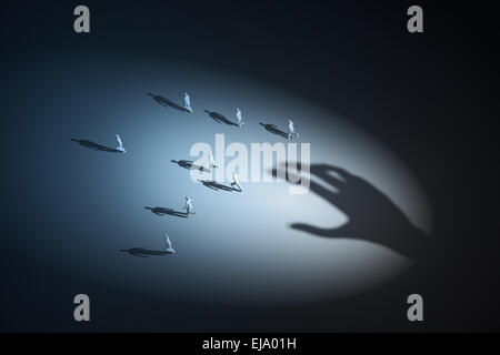 Groupe de personnes fuyant une main invisible Banque D'Images