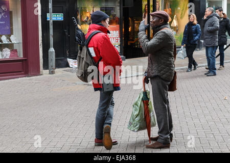 Rue Chugger encaisseur dans la Red Cross Society charity parlant à un donneur potentiel sur une rue de la ville Banque D'Images