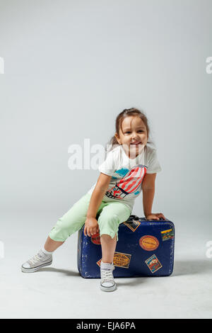 Fille sur une valise Banque D'Images