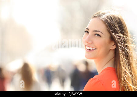 Femme de beauté avec un sourire parfait et des dents blanches en marchant dans la rue et looking at camera Banque D'Images