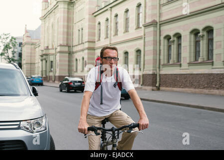 Homme touristiques sur un vélo à city street Banque D'Images