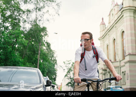 Homme touristiques sur un vélo à city street Banque D'Images