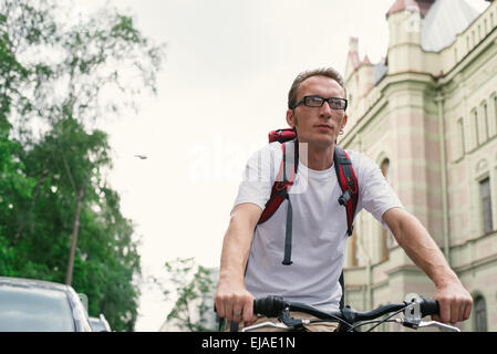 Homme touristiques sur un vélo à city street Banque D'Images