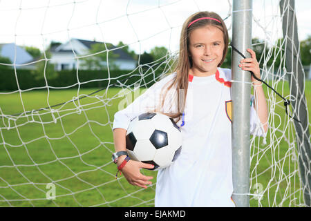 Kid jouer au soccer sur un champ Banque D'Images