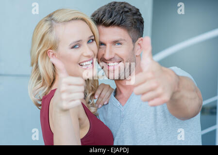 Happy laughing couple donnant un Thumbs up Banque D'Images