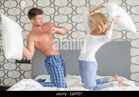 Playful couple ayant un pillow fight Banque D'Images