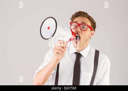 Geeky businessman shouting through megaphone Banque D'Images