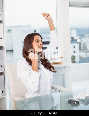 Cheerful businesswoman cheering in office Banque D'Images