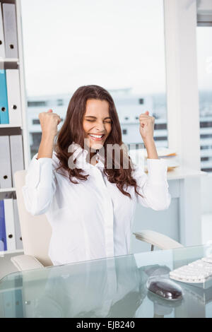 Cheerful businesswoman cheering in office Banque D'Images