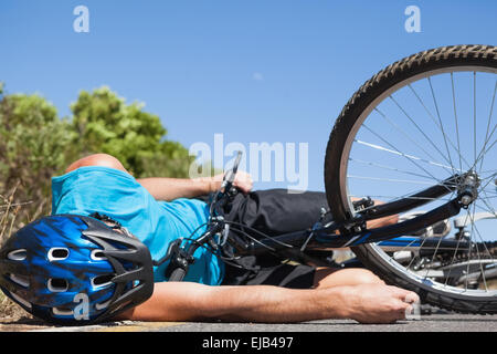 Cycliste couché sur la route après un accident Banque D'Images