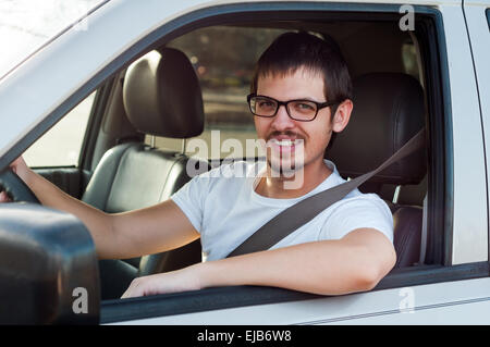 L'homme bon pilote est souriante dans sa voiture Banque D'Images