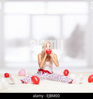 Femme blonde du gonflage des ballons Banque D'Images