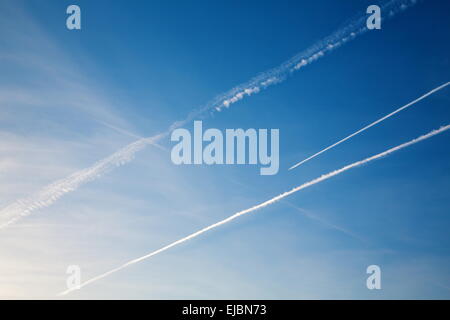 Avion avec trail contre le ciel bleu Banque D'Images