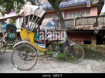 Rickshaw rider dort sur chariot dans l'ouest du Bengale, en Inde Banque D'Images