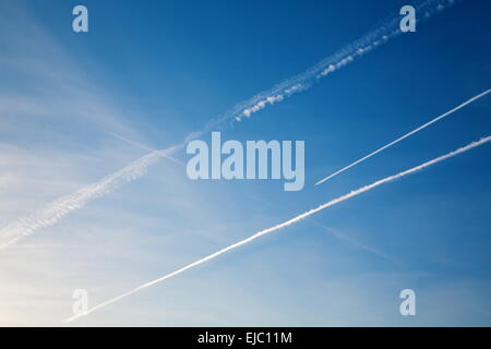 Avion avec trail contre le ciel bleu Banque D'Images