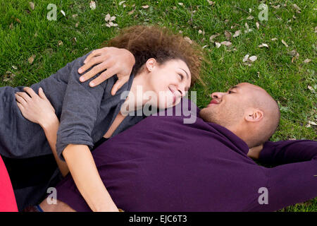 Jeune couple allongé dans l'herbe ensemble Banque D'Images