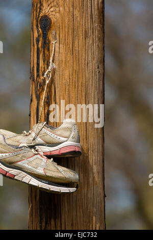 Une paire de Nike Air chaussures de tennis se balance d'un poteau de téléphone, haut au-dessus de la rue de Bloomington, Indiana. Banque D'Images