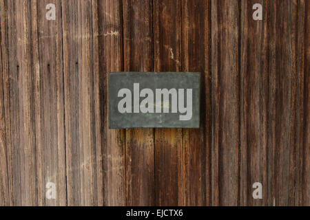 Vieille porte en bois avec plaque de métal blanc Banque D'Images