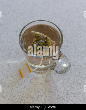 Sachet de camomille dans une tasse en verre sur la table Banque D'Images