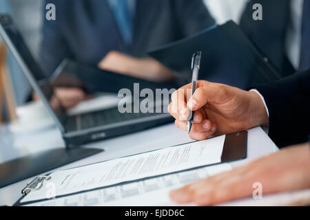 Photo en gros plan de mains de l'homme d'affaires avec stylo et documents Banque D'Images