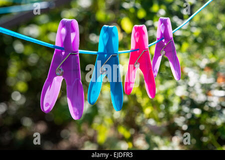 Quatre couleurs/vêtements clairs-chapeaux sur corde à linge dans le jardin domestique Gloucestershire England UK Banque D'Images