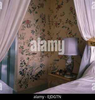 Détail de lit avec des rideaux blancs en chambre avec du papier peint de style Régence Banque D'Images