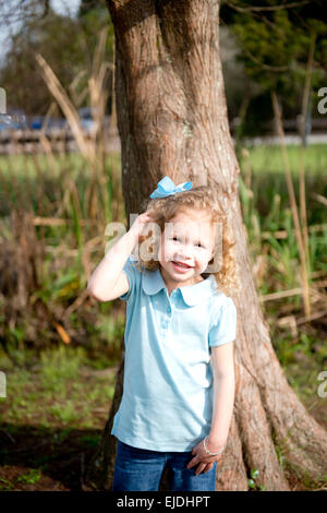 Jeune fille appuyée contre Oak tree, portrait Banque D'Images