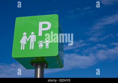 Parking réservé pour panneau vert pôle famille contre le ciel bleu Banque D'Images