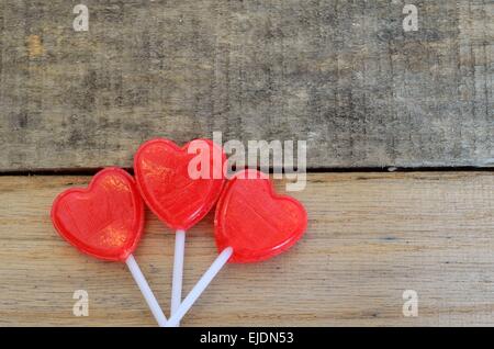 Sucettes en forme de coeur affiche sur fond de bois de palettes. Conception Festive Fun pour fêter les vacances ou les anniversaires, Amour, Saint Valentin. Banque D'Images