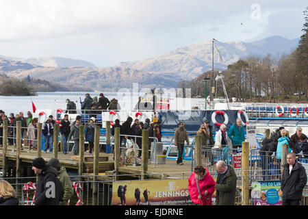 Le lac Windermere, Cumbria, Royaume-Uni. 24 mars, 2015. Météo : bateau de croisière arrive à l'embarcadère à l'atterrissage à Bowness-on-Windermere. Les touristes de profiter du soleil avec le dernier de la neige sur la haute lande Crédit : Gordon Shoosmith/Alamy Live News Banque D'Images