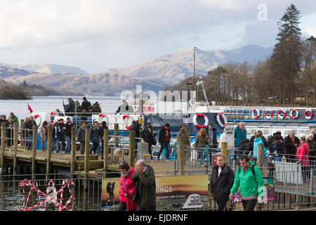 Le lac Windermere, Cumbria, Royaume-Uni. 24 mars, 2015. Météo : bateau de croisière arrive à l'embarcadère à l'atterrissage à Bowness-on-Windermere. Les touristes de profiter du soleil avec le dernier de la neige sur la haute lande Crédit : Gordon Shoosmith/Alamy Live News Banque D'Images