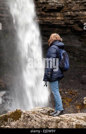 Randonneur Femme regardant Hardraw Force cascade, North Yorkshire, England UK Banque D'Images